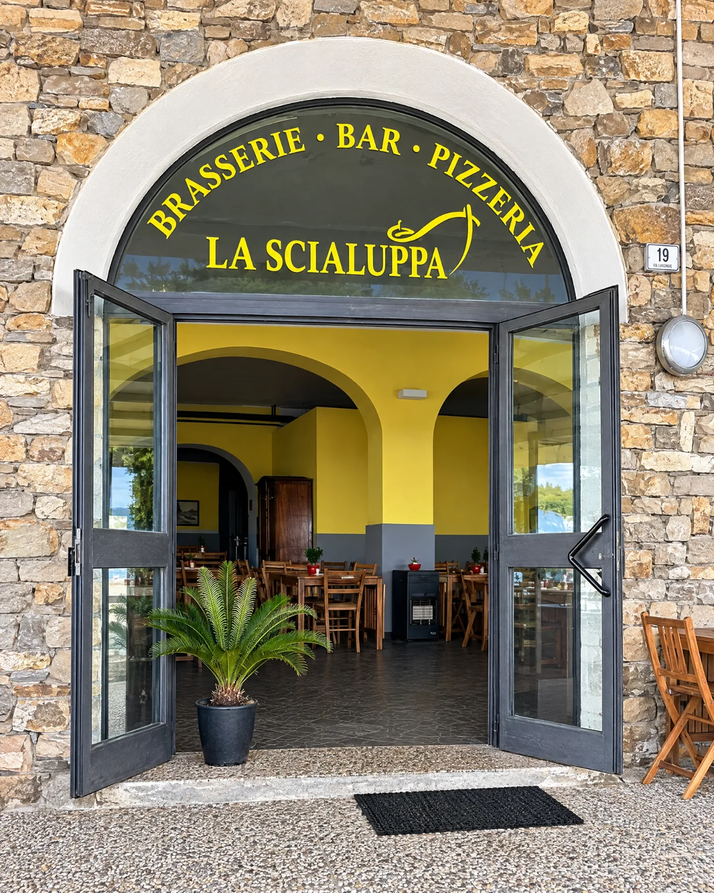 L’ingresso di La Scialuppa: la grande porta ad arco con l’insegna Brasserie · Bar · Pizzeria