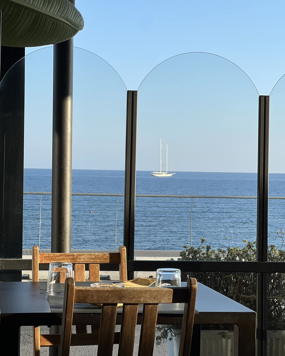 Tavolo in veranda con il mare e una barca a vela all'orizzonte
